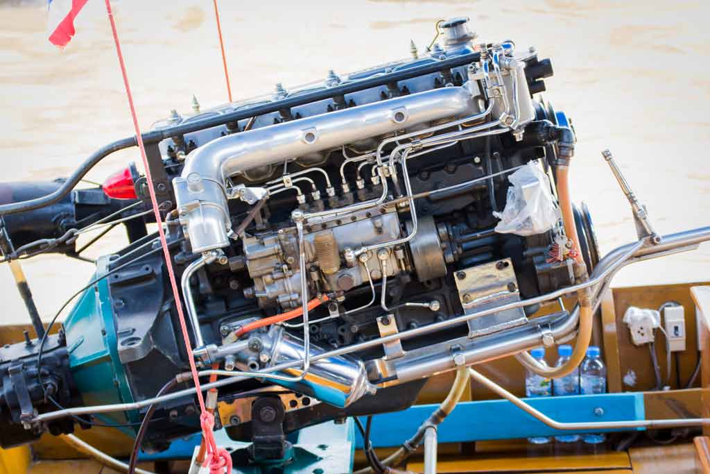 A close-up of a boat engine's cables, ties, hoses, and connections