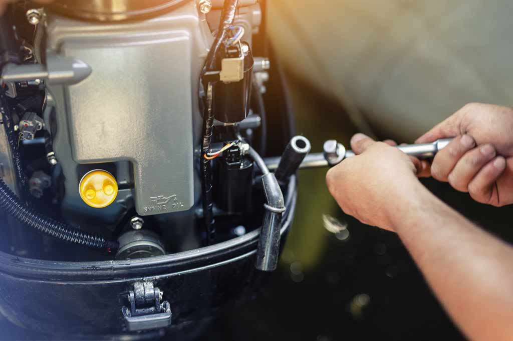 A close-up of a man working on his boat engine