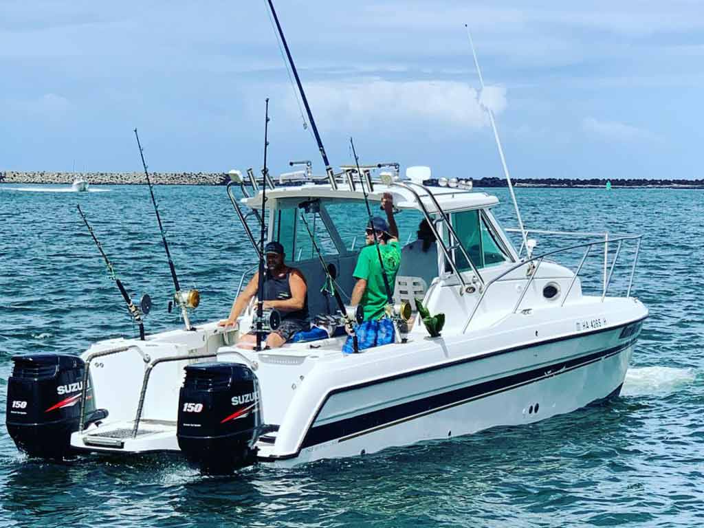 A view of anglers on a boat charter fishing in the nearshore waters of Kauai