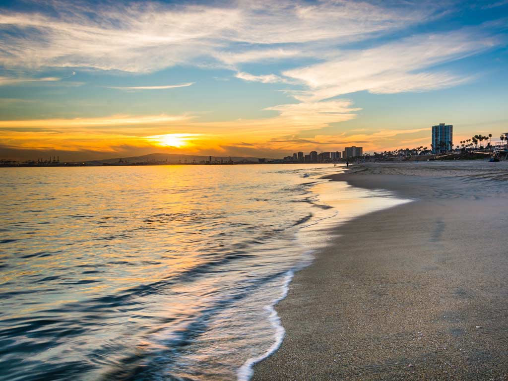 A photo of a beach at sunset in Long Beach, California.