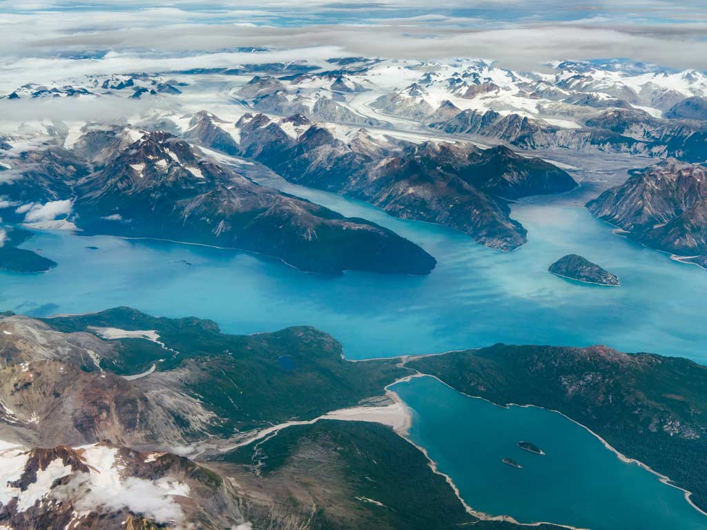 An aerial shot of the Alaskan fjords and the surrounding mountains.