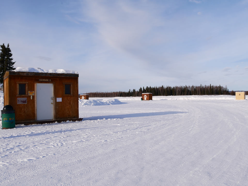 A photo of ice fishing shanties on a lake in Alaska.