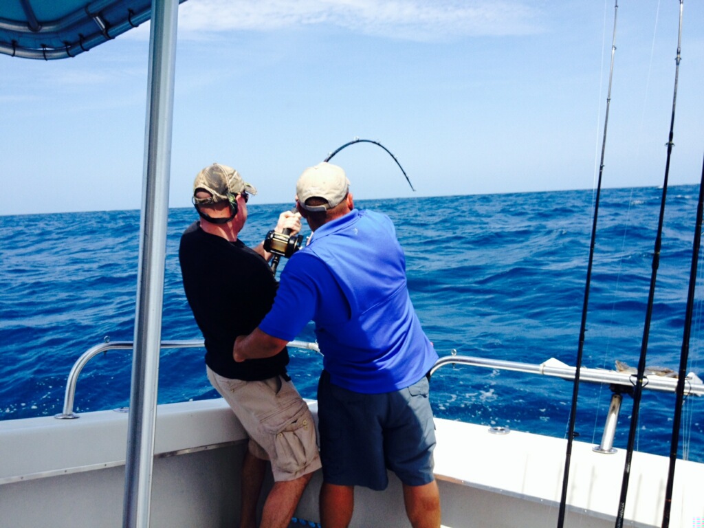 Two anglers fishing on a boat offshore in Naples, FL