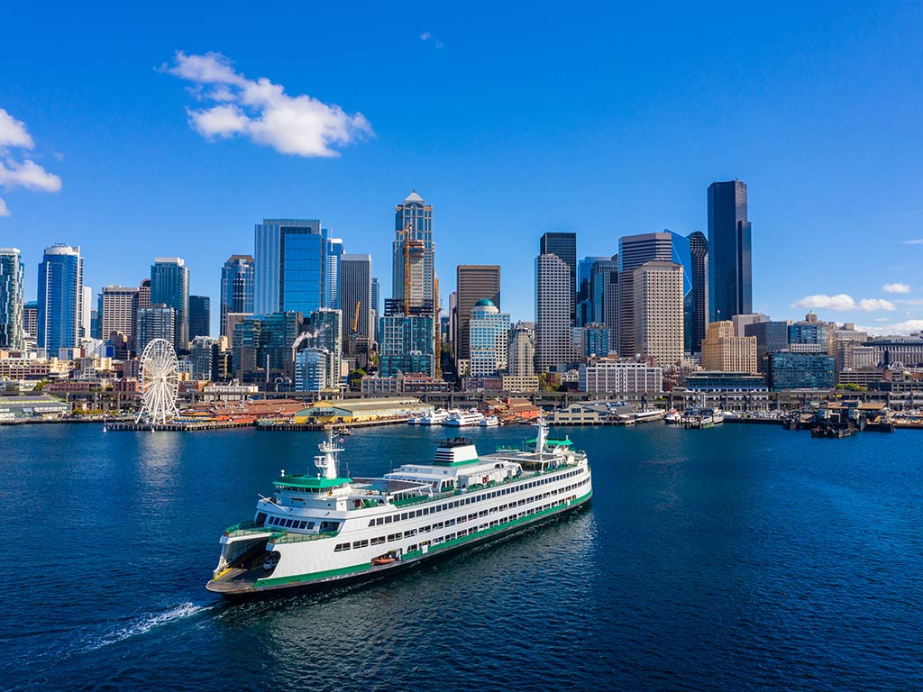 An aerial view of Seattle around the Fourth of July with a large ship in the foreground and some fishing boats in the background.