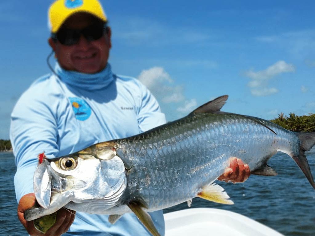 A photo featuring an angler holding a freshly caught Tarpon, fishing with Nano Guerrero, Belize