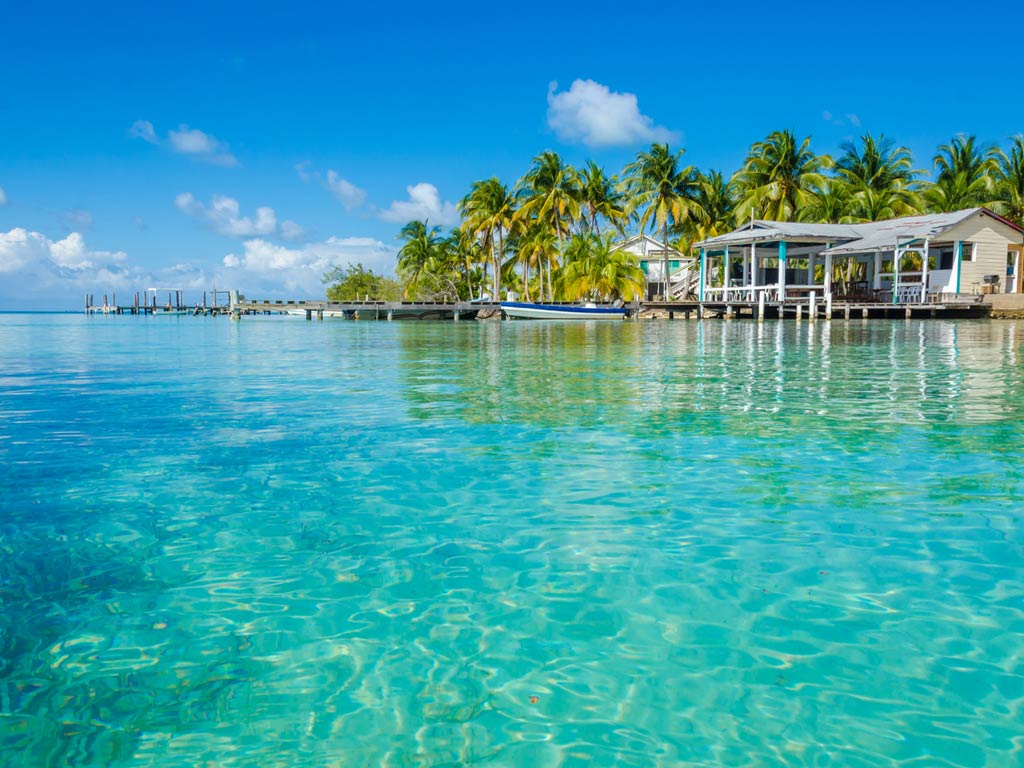 A photo featuring crystal clear waters and shoreline in Ambergris Caye, Belize on a sunny day