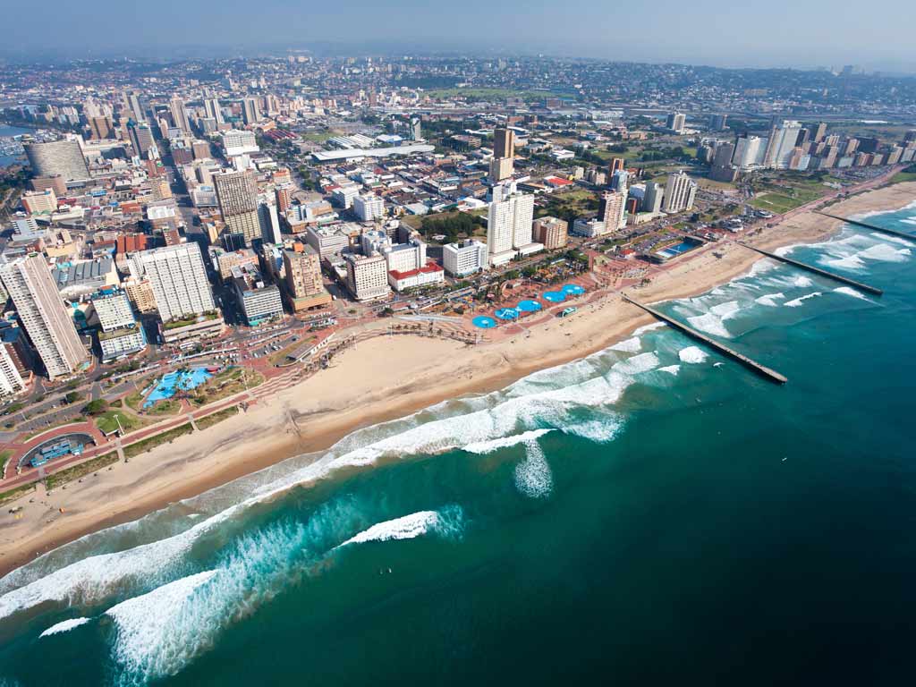 An aerial view of the ocean, beach, and city of Durban