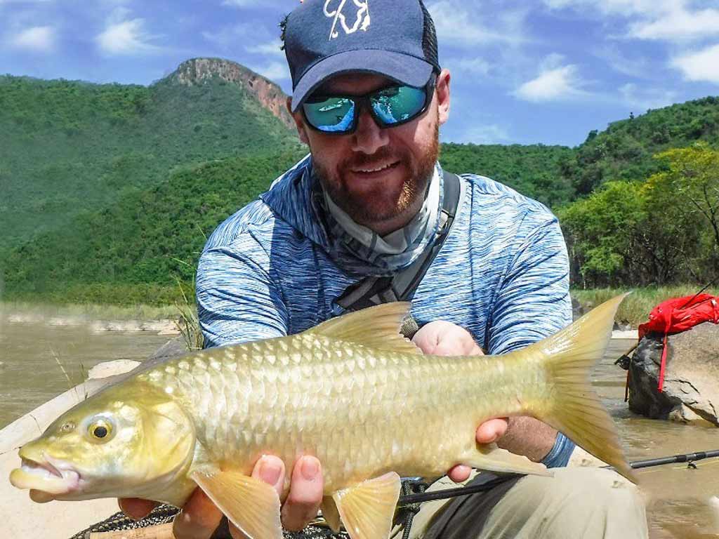 A wader holding Yellowfish caught while fishing in Durban’s freshwater fishery