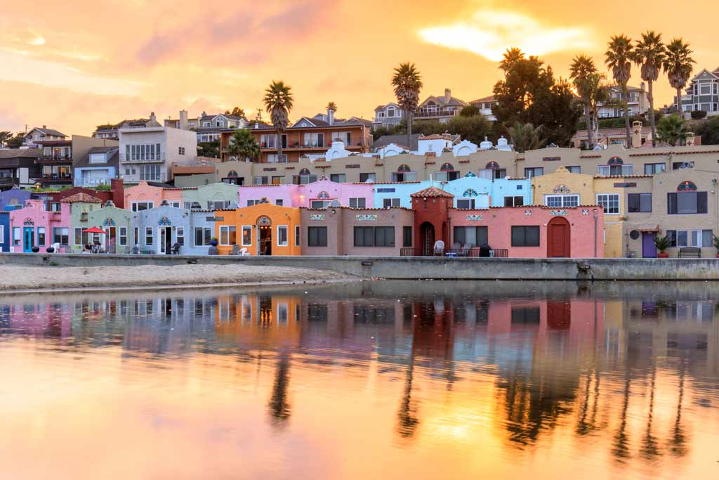 A view from the water of colorful houses in Santa Cruz, California at sunset