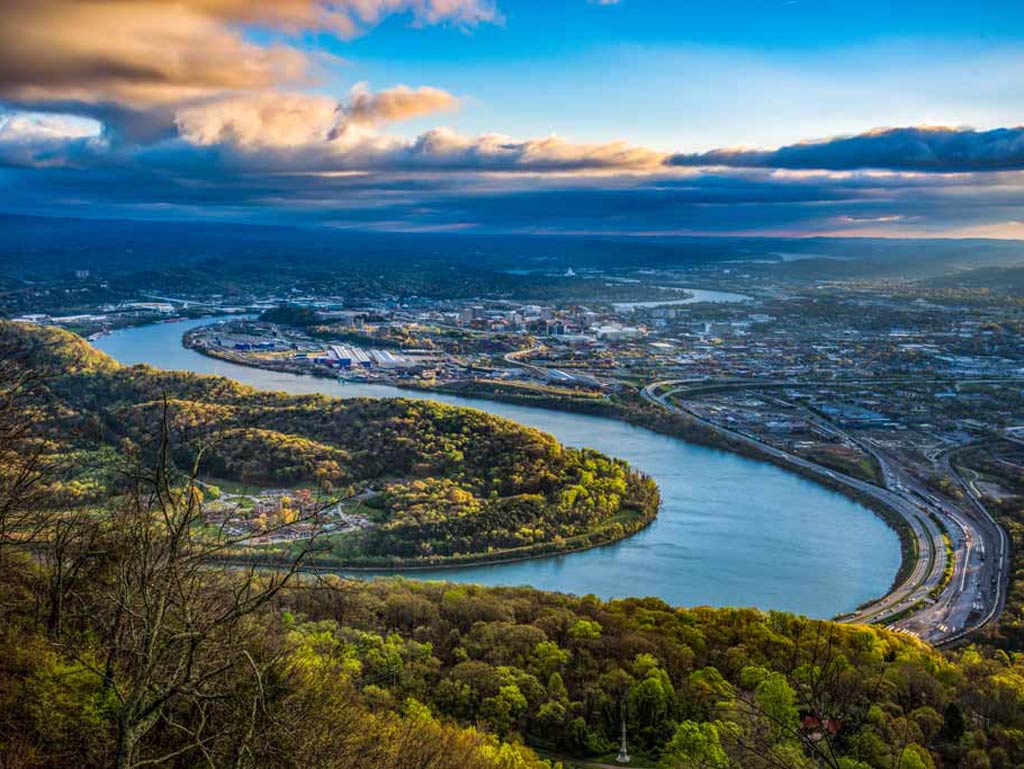 An aerial view of the Tennessee River surrounded by greenery and houses along the shoreline