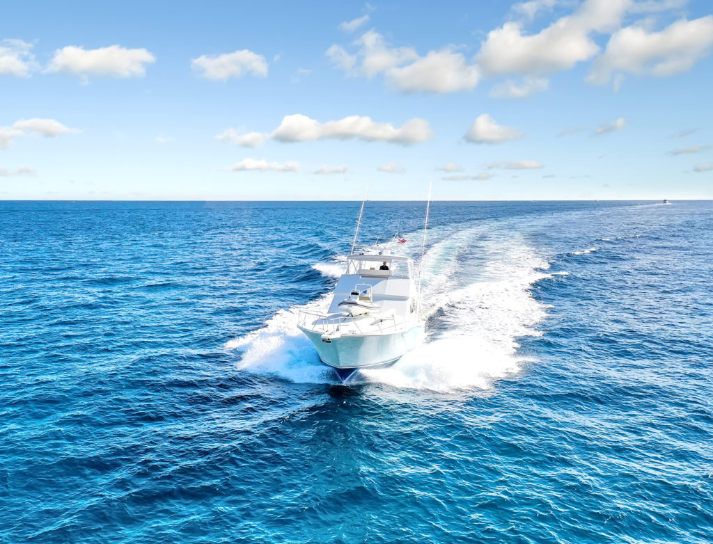 A moving charter fishing boat on the waters of the Gulf Stream with another boat behind it in Miami Beach, Florida