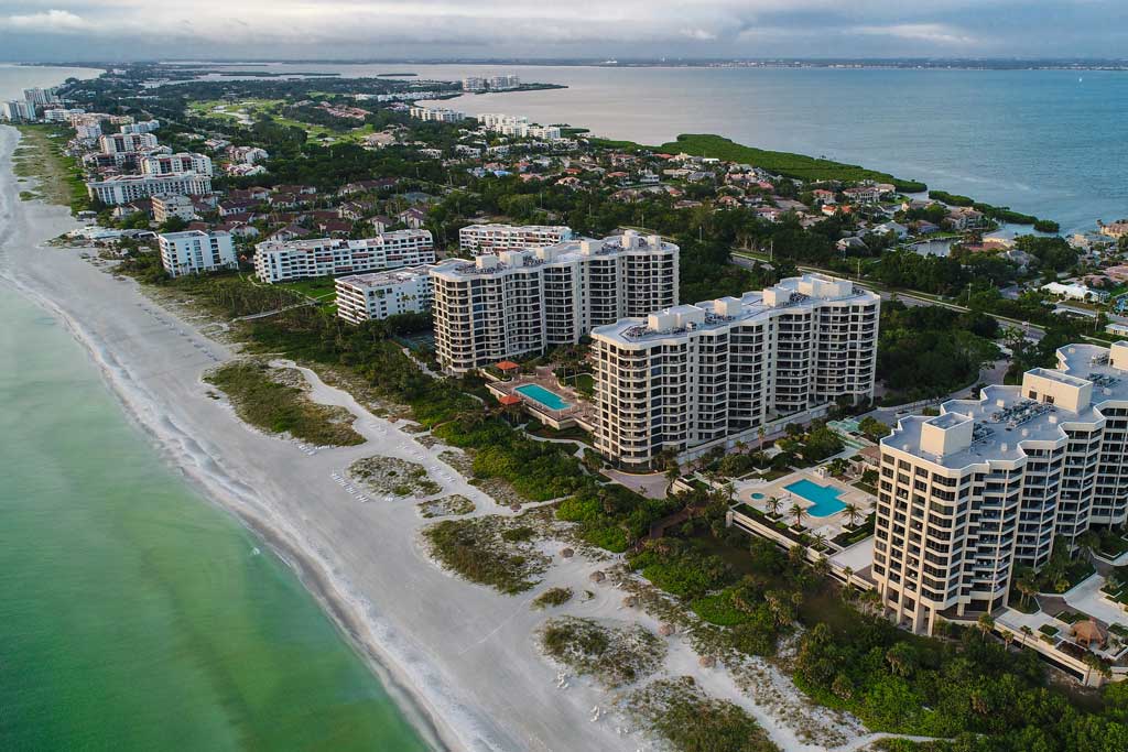 An aerial view of Longboat Key's downtown and beaches, with the Gulf of Mexico in the foreground and the bay in the distance