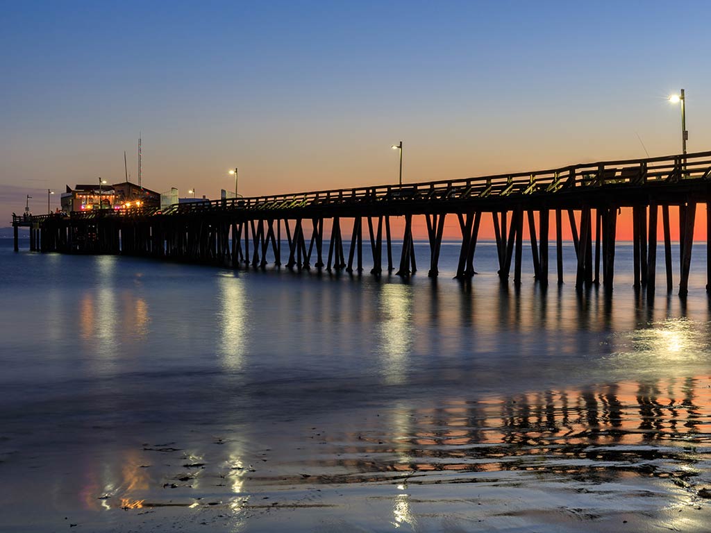 A view from the town of Capitola Wharf fishing pier just after sunset, stretching out into the water on a clear night