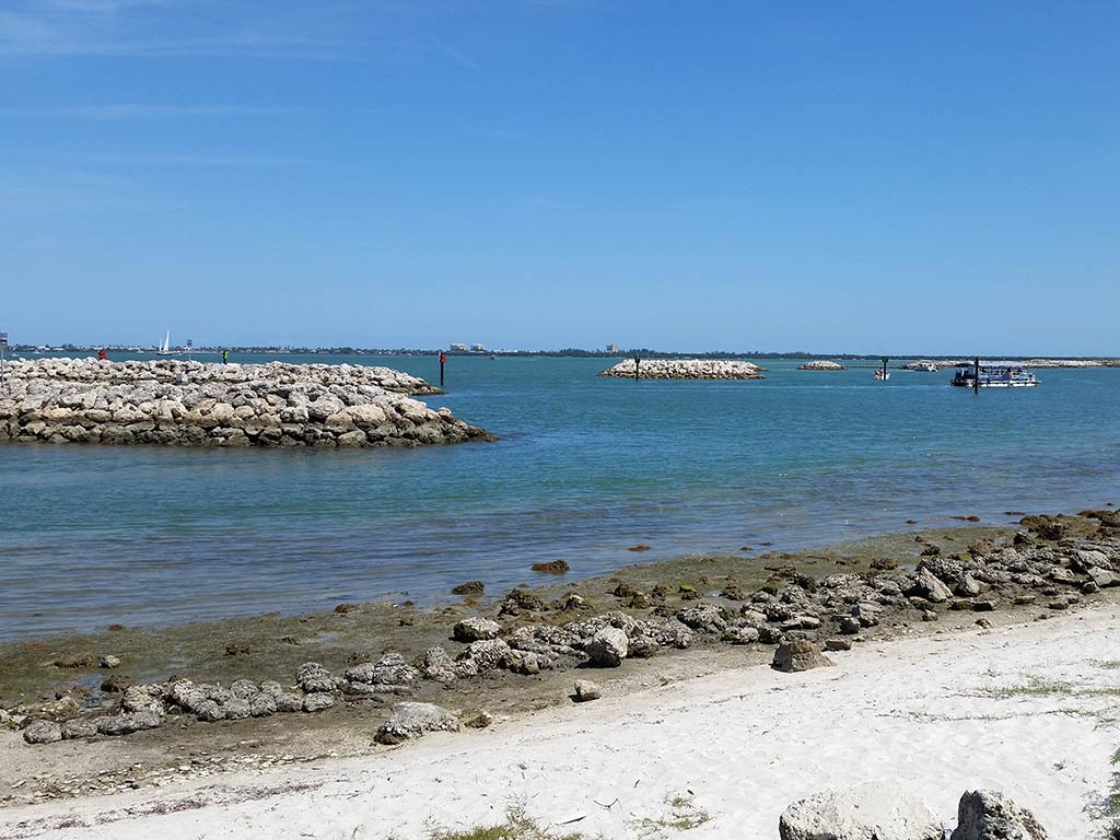 A view from a rocky shoreline towards some other rocky jetties in the Indian River Lagoon near Vero Beach on a clear day