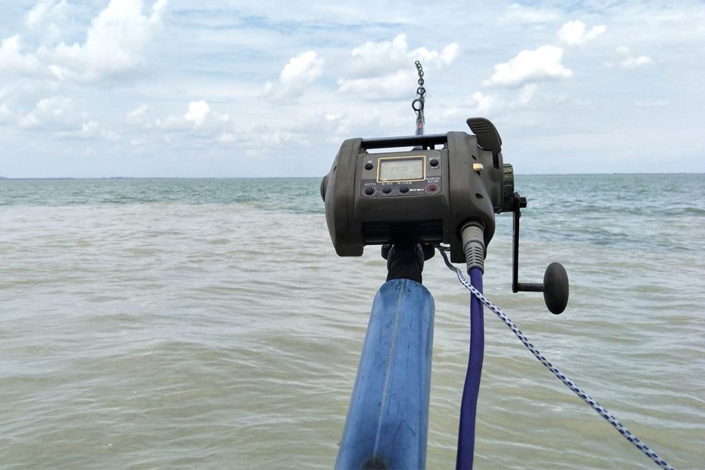 An electric reel drops a line deep into the ocean