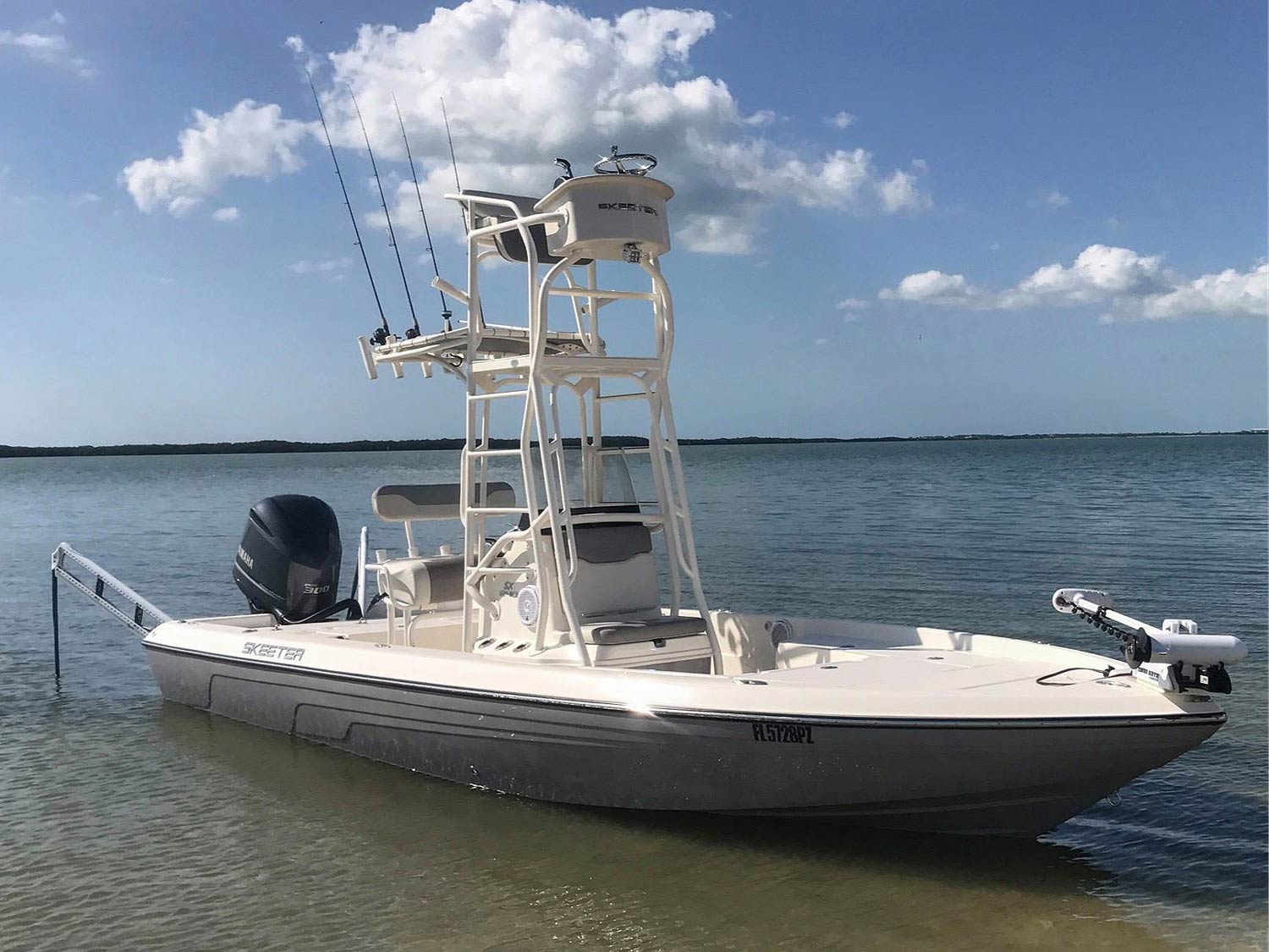 A flats fishing boat with a trolling motor and a flybridge on a lake