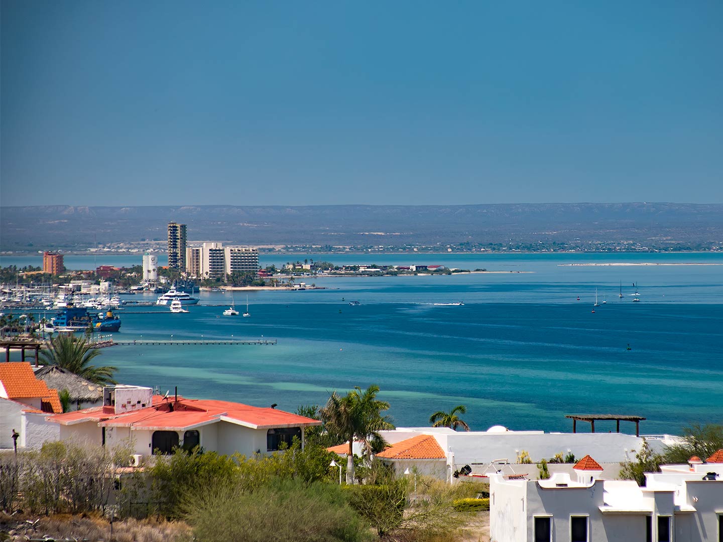 An aerial view of a marina in La Paz, Mexico, with boats heading to and fro.