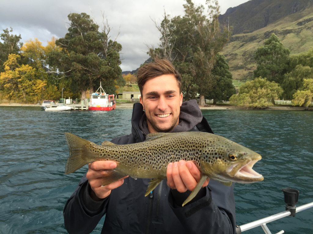 an angler holding a Trout on Lake Wanaka