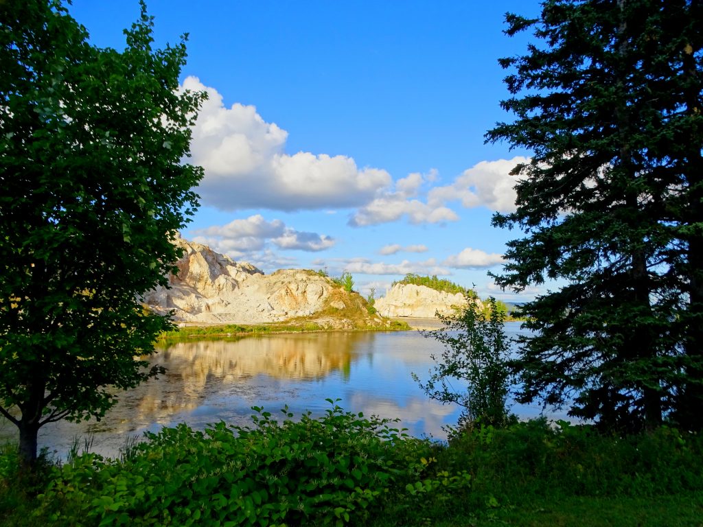 a view of Bras d'Or Lake through a couple of arching trees