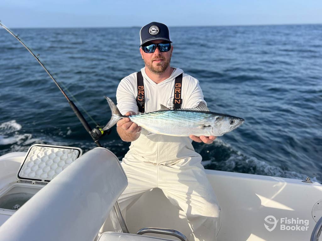 An angler standing on a charter fishing boat while posing with Atlantic Bonito caught with Walk It Back Charters from Wilmington, North Carolina, United States