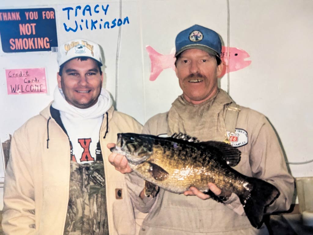 The photo features Tracy Wilkinson and Timothy Tim Teague who caught the Texas Smallmouth Bass state record in 1998 on Lake Meredith