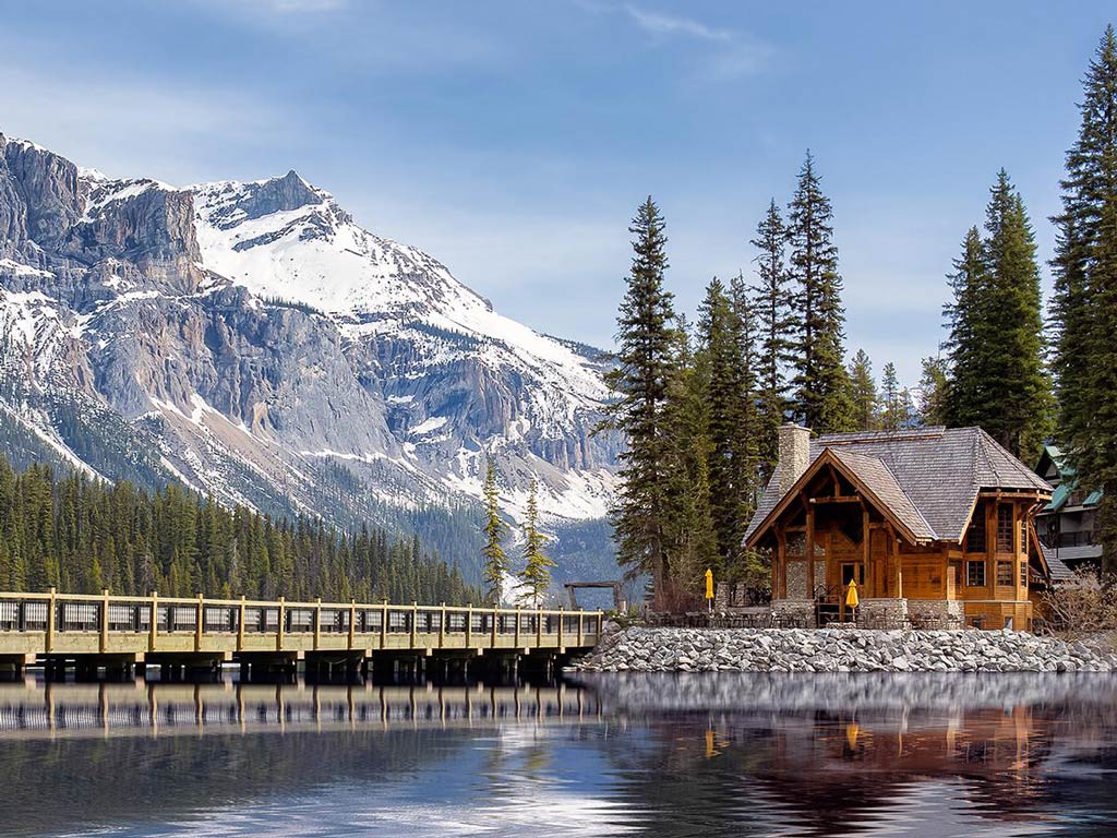 A view of the water, a cabin, a road, and a snow-covered mountain somewhere in British Columbia in Canada