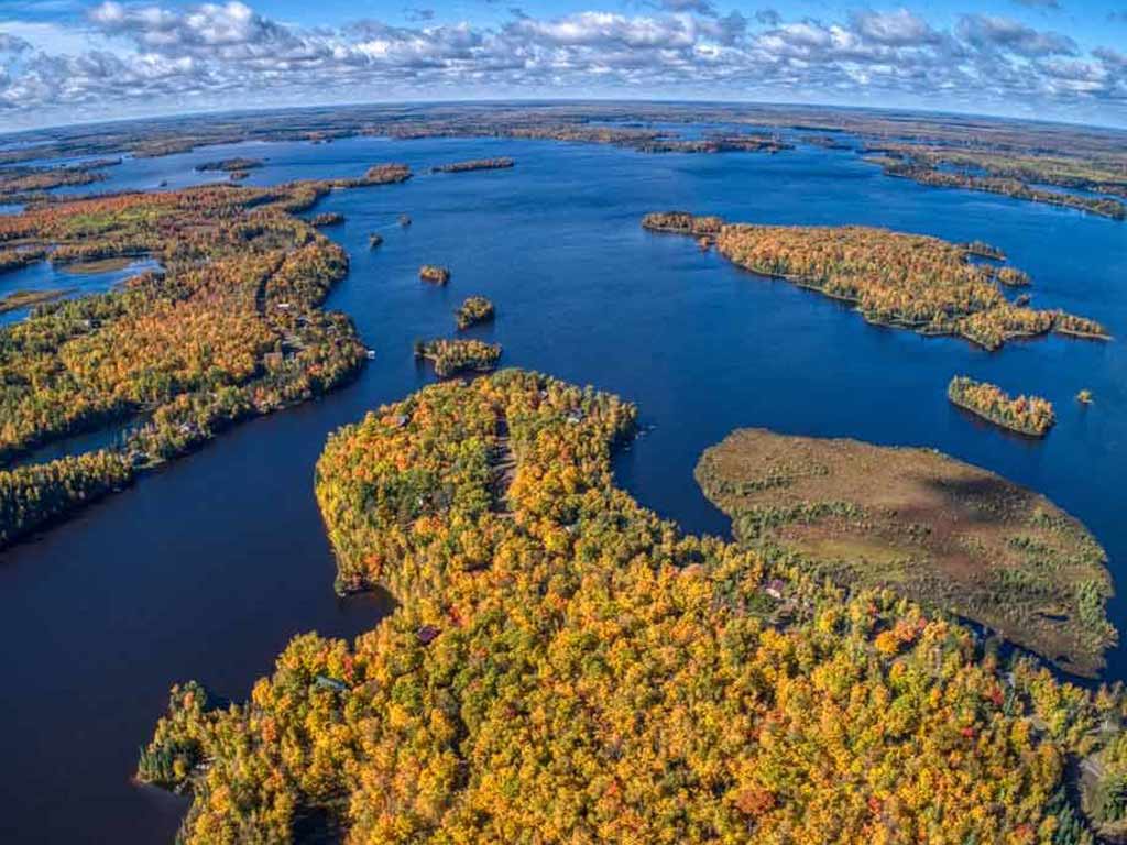 An aerial view of the lakes and forests in Minnesota on a day with sunny intervals.