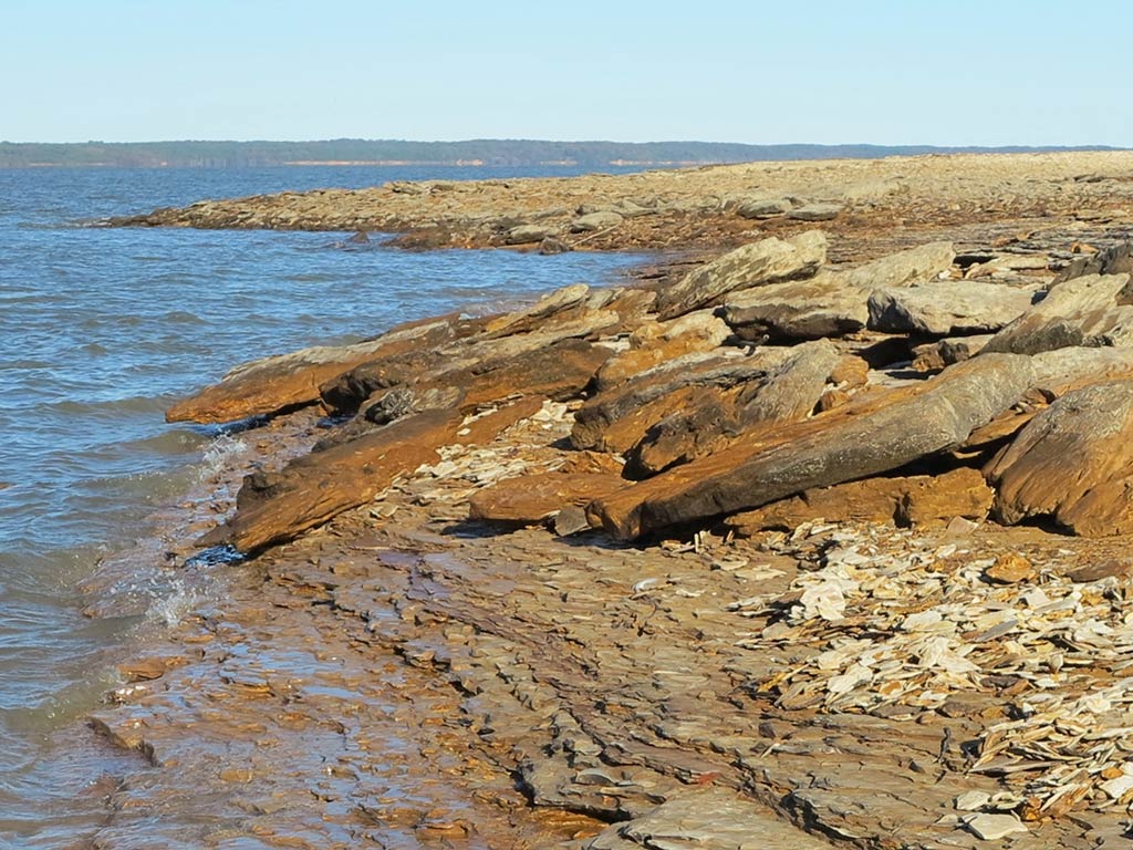 A view of Grenada Lake in Mississippi from a rocky shoreline on a clear day