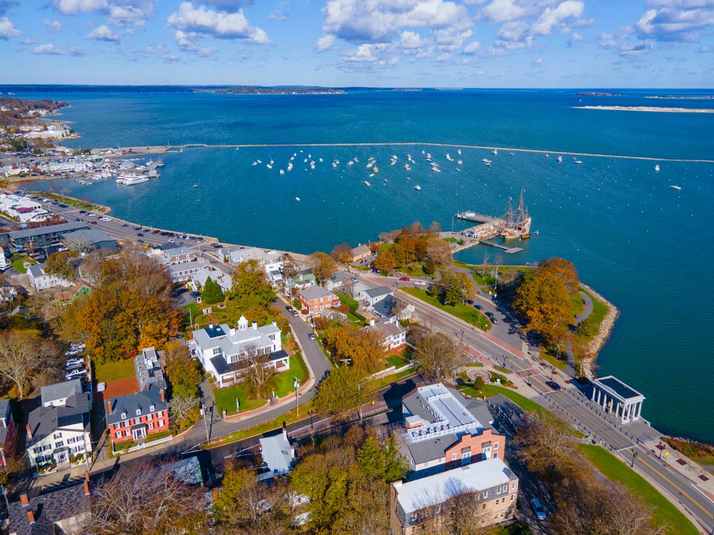 An aerial view of the Mayflower II ship and the town of Plymouth in Massachusetts seen during a bright and sunny day around Thanksgiving