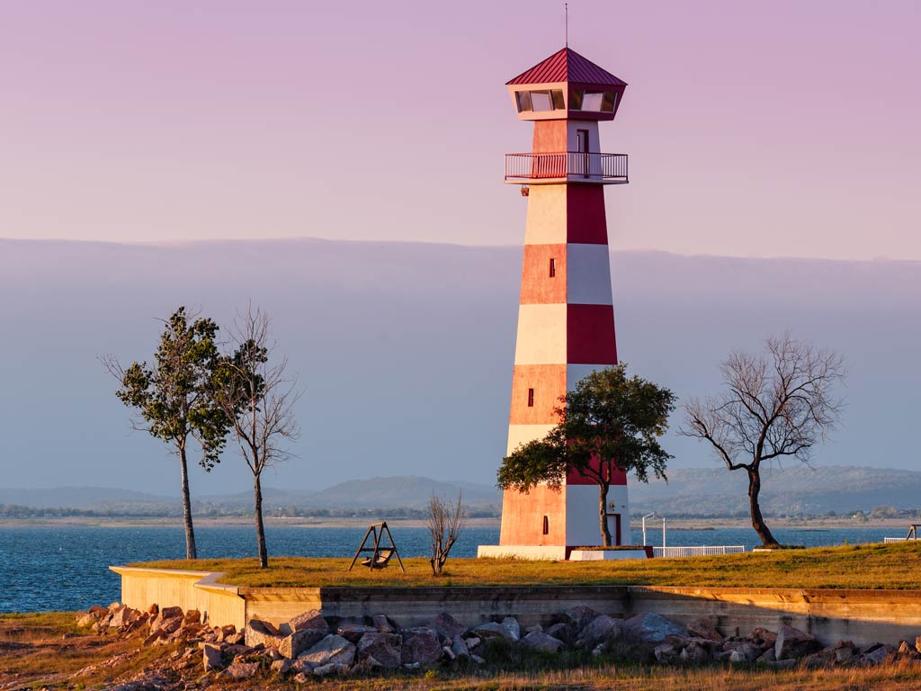 A stunning sunset view of the lighthouse posing proudly on the location next to Lake Buchanan during the Thanksgiving fishing season in Texas