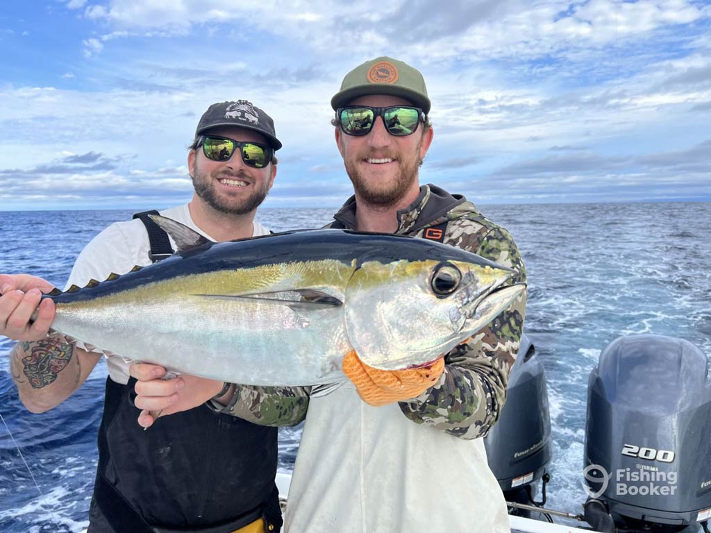 A photo featuring two proud anglers standing on a North Carolina charter boat and posing with a Tuna they caught offshore