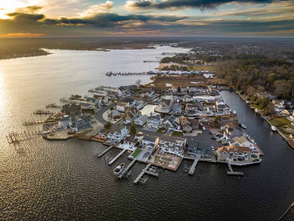 An aerial view of Brick Township in New Jersey, with various piers and docked boats visible along the shore and houses visible on land.