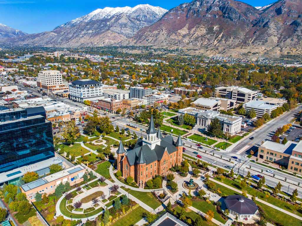 An aerial view of Provo in Utah, with the striking Y Mountain overlooking the city and a church visible in the foreground