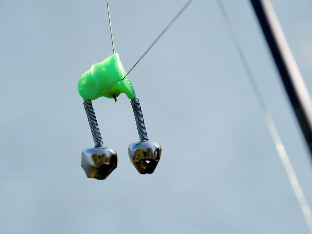 A closeup of a bell on the end of a fishing line, potentially used for catching deep sea fish