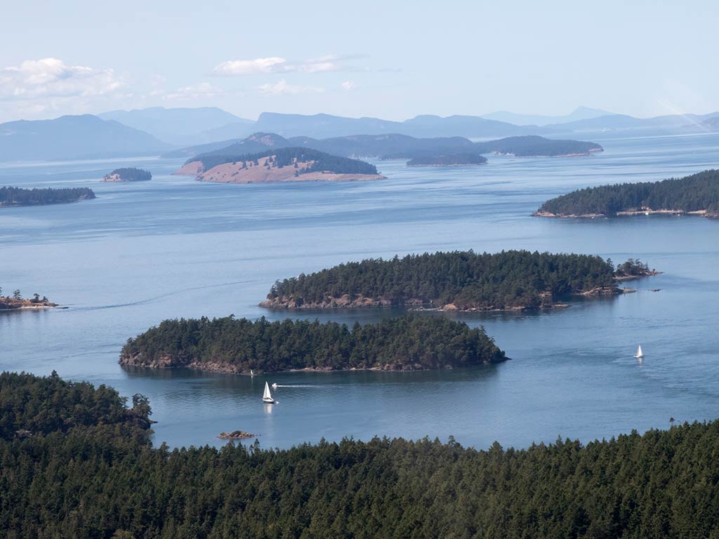 A view of a few small islands that make up the San Juan Islands on a clear day.