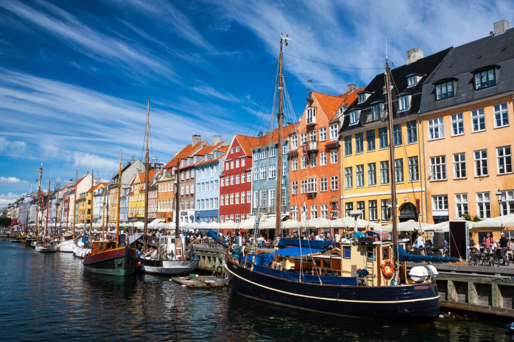 Bunte H&auml;userfassaden in Kopenhagen. Davor liegen Segelboote in einem Kanal.