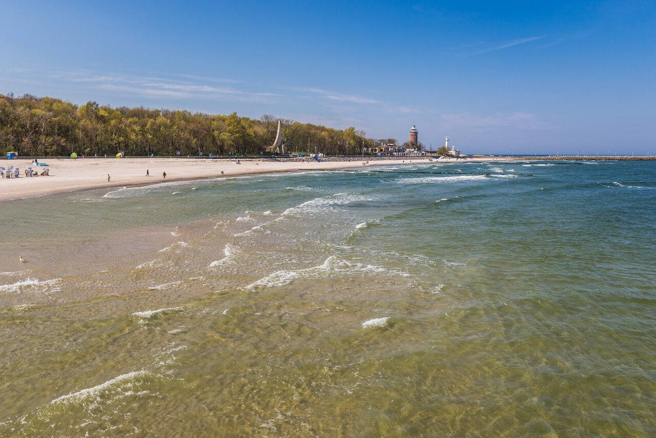 Der Strand von Kołobrzeg, mittig im Hintergrund ist der alte Leuchtturm zu sehen.