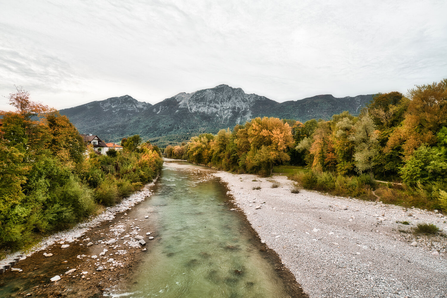 Die Saalach flie&szlig;t von vorne nach hinten durch das Bild. Rechts ist ein Kiesstrand zu sehen und im Hintergrund sind Berge.