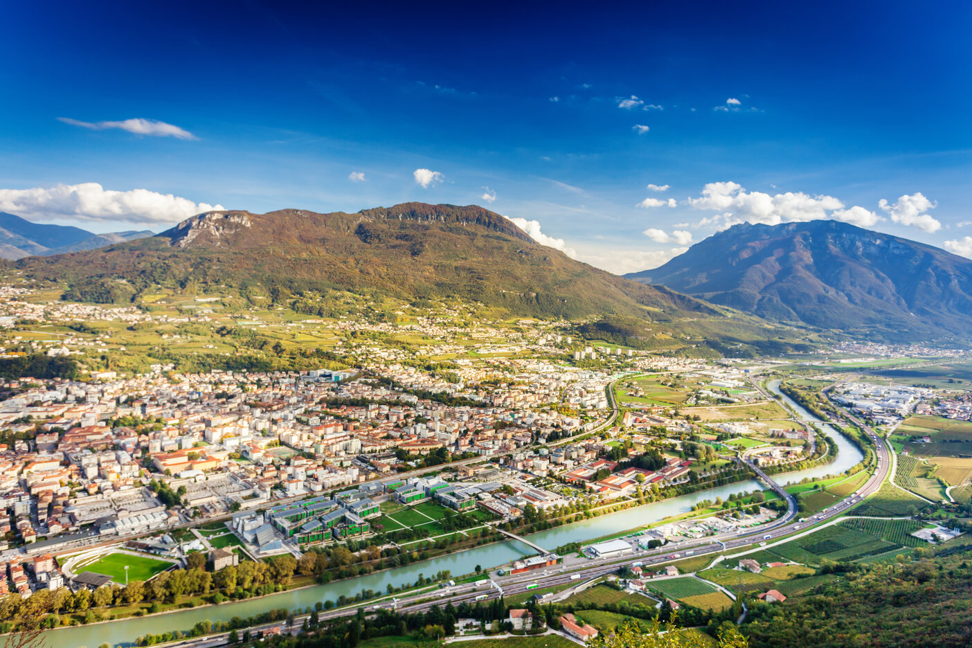 Ein Luftbild von Trient in Italien, mit der quer verlaufenden Etsch.