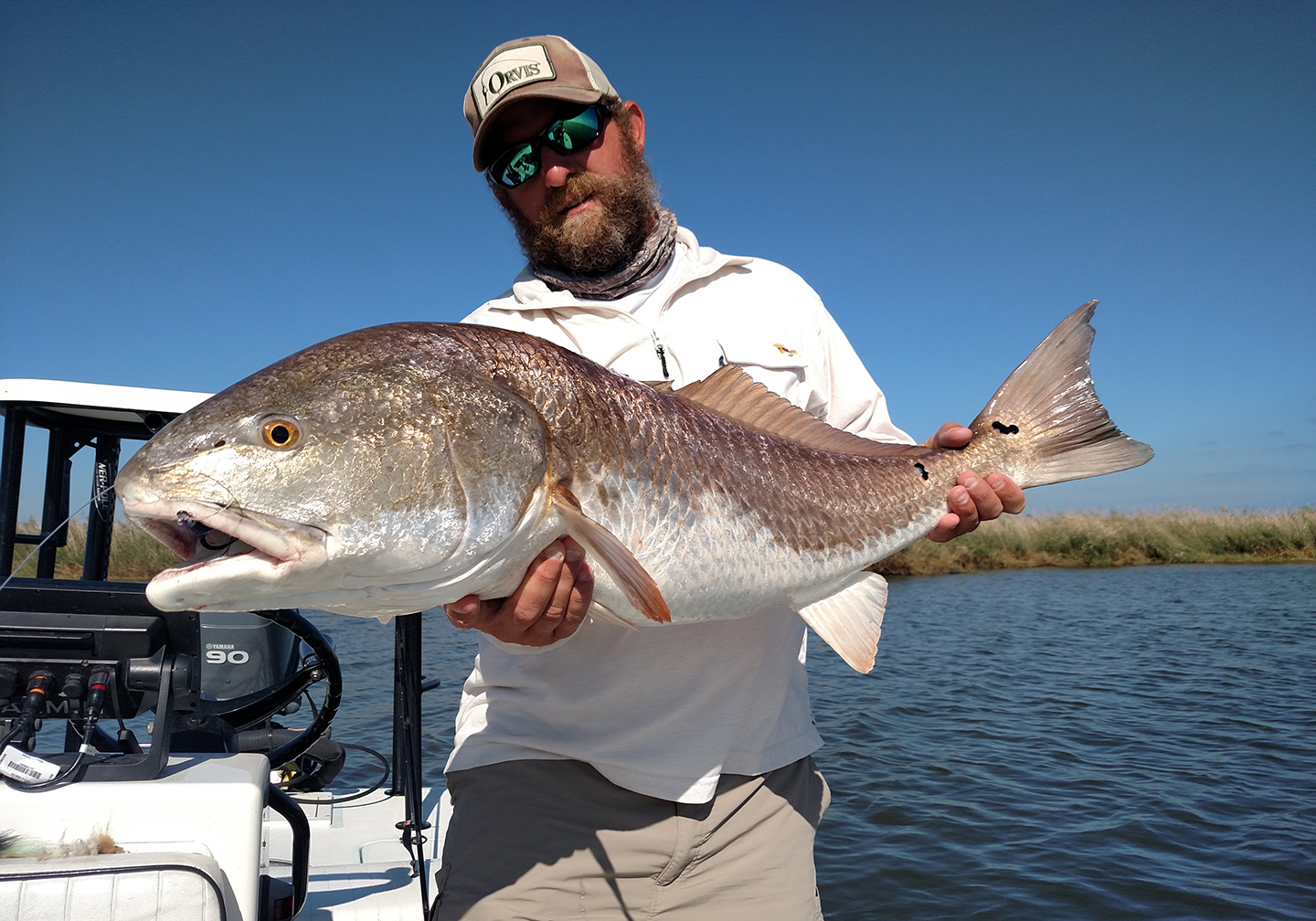 Ein Angler auf einem Fischerboot h&auml;lt einen gro&szlig;en Roten Trommler.