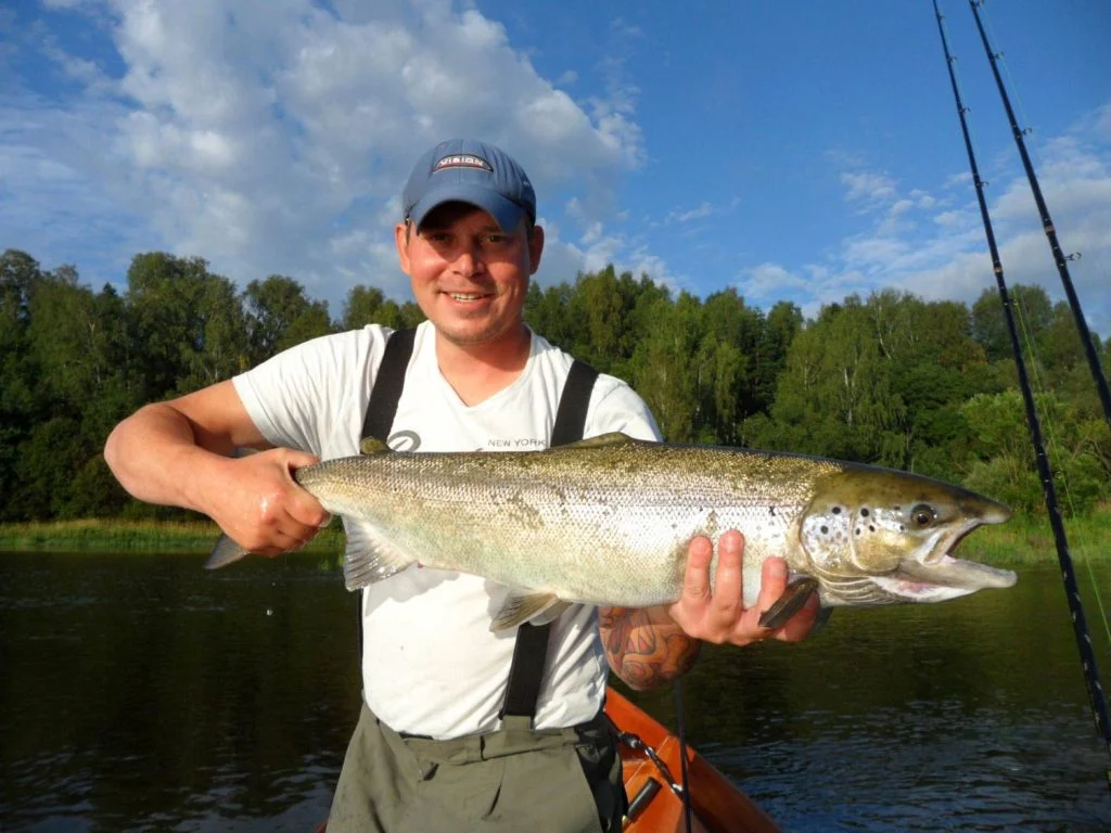 Ein finnischer Angler, der einen Lachs h&auml;lt.