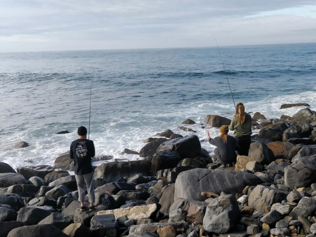 Drei Angler stehen an den H&auml;ngen einer Klippe und angeln.