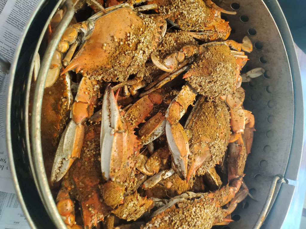 A large pot filled with cooked Crabs, all generously coated with spices and seasoning.