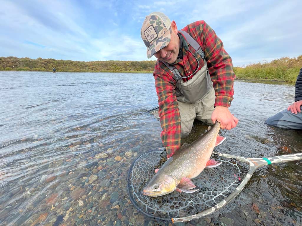 Dave Finkel of Wild Salmon Center releases a sizeable Dolly Varden in a shallow river in Alaska.