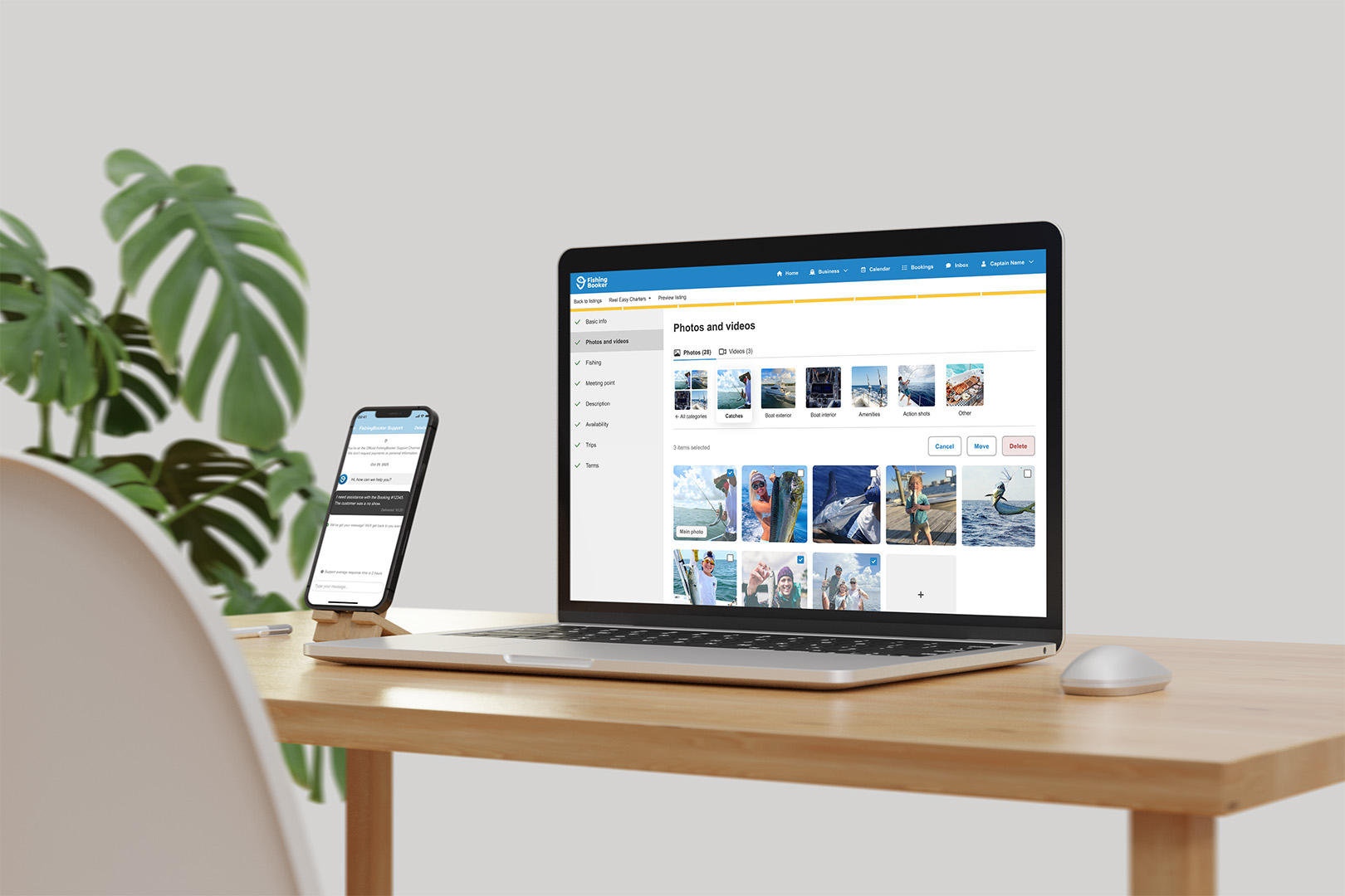 There's a laptop and smartphone on a wooden desk showing a media management website; there's also a plant and mouse on the desk.