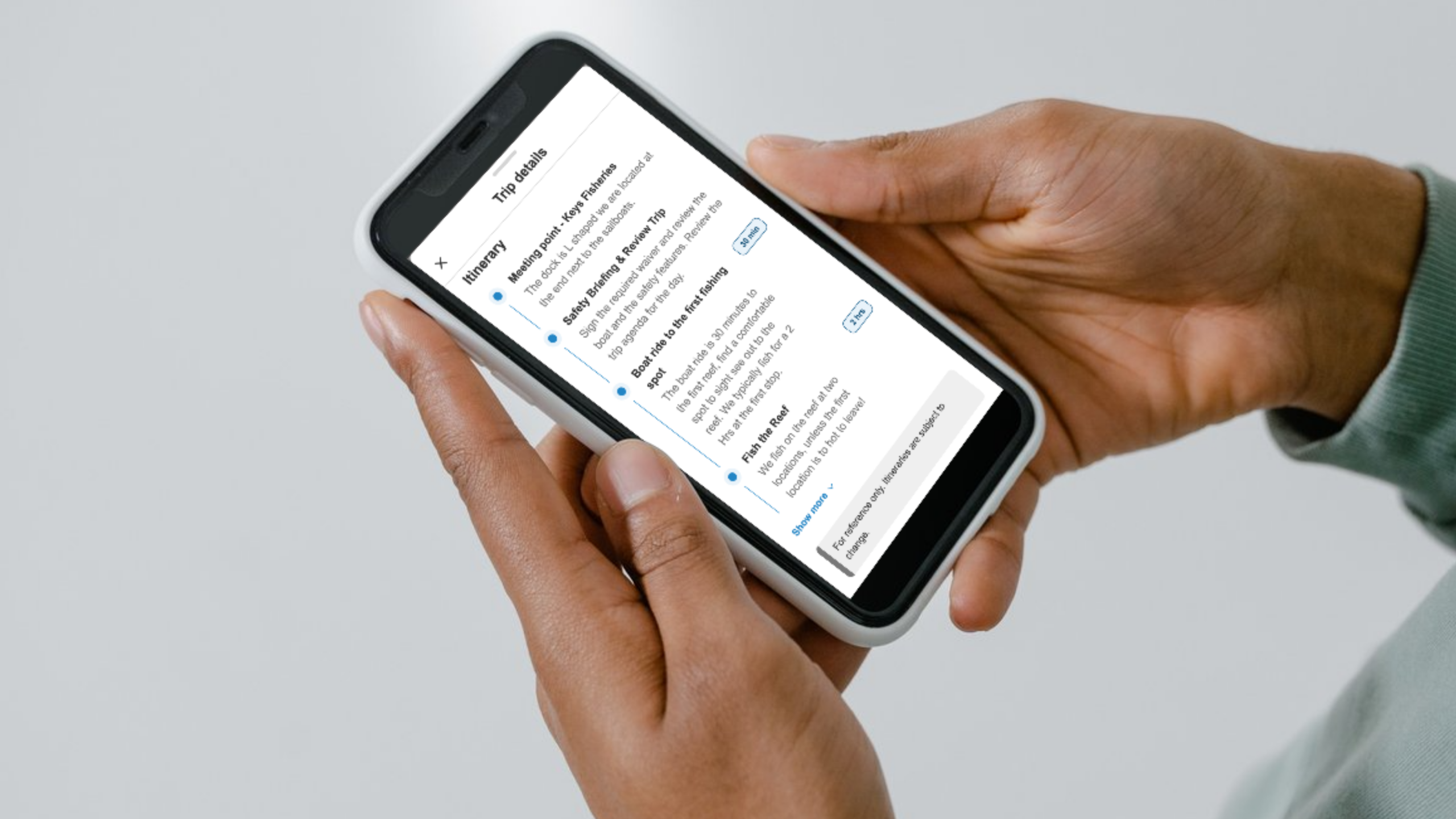 Someone's holding a smartphone that shows a trip itinerary on FishingBooker.