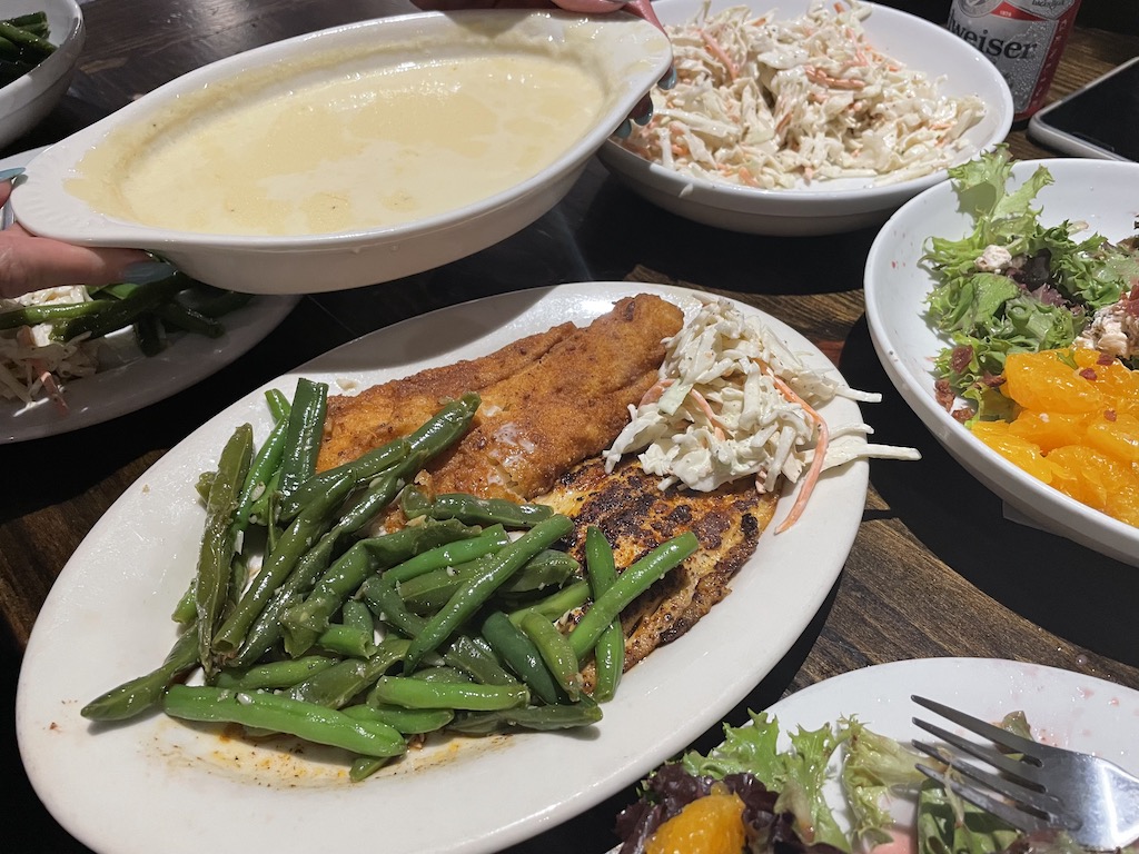 A closeup of a freshly-cooked fish, breaded and with green beans, after a successful fishing trip in Alabama's beaches.